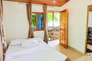 a bedroom with a bed and a balcony at El Ranchito de Turbo in Turbo