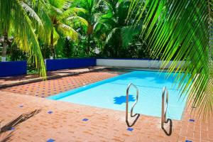 a swimming pool with a palm tree in the background at El Ranchito de Turbo in Turbo