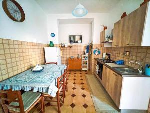 a small kitchen with a table and a sink at Casa Primula - Family Country House immersa nel verde a 5 min dal Mare in Ricadi