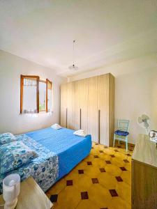 a bedroom with a blue bed and a blue chair at Casa Primula - Family Country House immersa nel verde a 5 min dal Mare in Ricadi