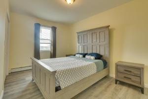 a bedroom with a large bed with a wooden headboard at Explore NYC, Parks & Beaches! Top-Floor Apt in Mount Vernon