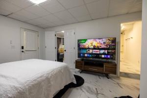 a bedroom with a bed and a flat screen tv at Studio•Basement• Back Entry Basement•1BRD•Ste B in Lawrenceville