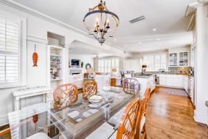 a dining room and kitchen with a glass table and chairs at Beach cottage with private pool & spa, ocean views, & shared pool access in Saint Simons Island +30 photos
