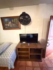 a room with a bed and a fan on the wall at The Cabo Cush Hotel in Cabo San Lucas