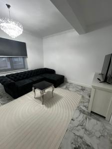 a living room with a black couch and a table at Gosen Grand Residence in Sângeorz-Băi