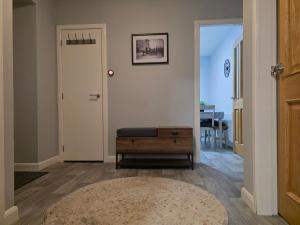 a hallway with a door and a stool and a rug at Wick Harbour View Apartment - 2 Beds - Sleeps 3 - Ideal for Couples in Wick