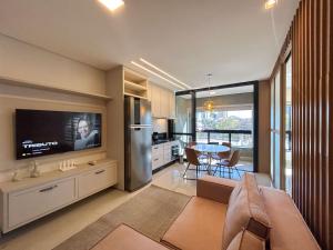 a kitchen and living room with a television and a table at Studio Central, Tranquilo e Confortavel in Campo Grande