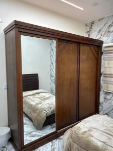 a bedroom with a large wooden cabinet with a bed at golden apartment - karak - thaniyah الكرك الثنية in Kerak