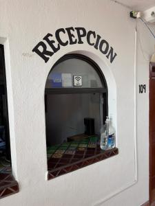 a white wall with a sign for a restaurant at The Cabo Cush Hotel in Cabo San Lucas