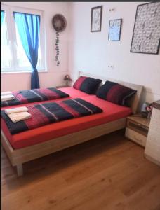 a bedroom with a large bed with red sheets and a window at Zimmervermietung Pargen in Daun +6 photos