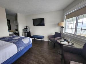 a hotel room with a bed and a couch and a table at Brio Beach Inn in Traverse City