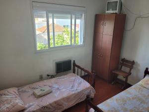 a small bedroom with two beds and a window at Novo Hotel in Caçapava do Sul +10 photos