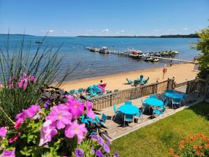 a beach with tables and chairs and people on the beach at Brio Beach Inn in Traverse City