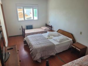 a hotel room with two beds and a window at Novo Hotel in Caçapava do Sul