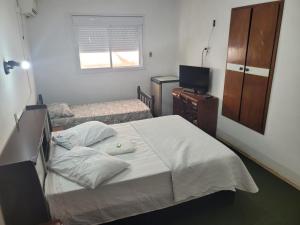 a small bedroom with a bed and a television at Novo Hotel in Caçapava do Sul