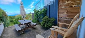 a patio with a table and chairs and an umbrella at Lar da Rita - One bedroom apartment in Água Retorta