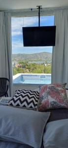 a bedroom with a bed and a large window at Anima Lodge in Villa Carlos Paz