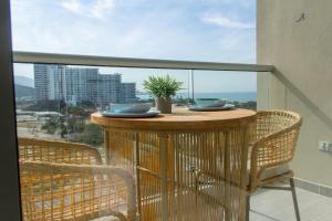 a table on a balcony with a view of the ocean at Vela Mare Suite in Santa Marta
