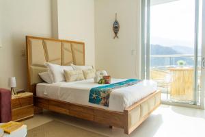 a bedroom with a bed and a large window at Vela Mare Suite in Santa Marta +73 photos