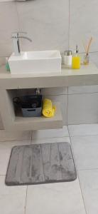 a bathroom with a sink and a rug under a sink at Anima Lodge in Villa Carlos Paz
