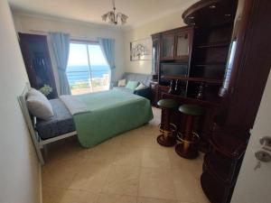 a bedroom with a bed and a television and a window at Forum Madeira dla par in Funchal