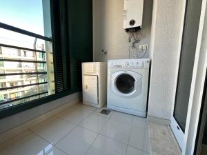 a laundry room with a washing machine and a window at Forum Madeira dla par in Funchal