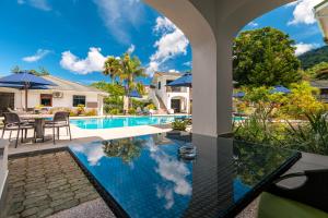 a villa with a swimming pool and a house at Sun Properties and Resort Hotel in Beau Vallon