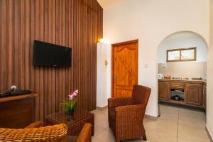 a living room with a television on a wooden wall at Sun Properties and Resort Hotel in Beau Vallon