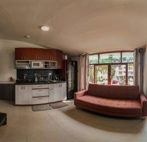 a living room with a red couch and a kitchen at Apartment E18 UPAO 2nd Floor in Trujillo