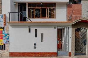 a white house with a door and a balcony at Apartment E18 UPAO 2nd Floor in Trujillo