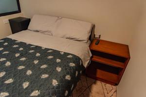a small bedroom with a bed and a night stand at Apartment E18 UPAO 2nd Floor in Trujillo