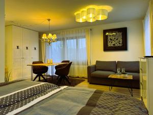 a bedroom with a bed and a couch and a table at Ferienwohnung Waldrose am Titisee in Titisee