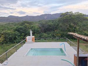 a hot tub on a deck with a cross in the background at Rancho Primavera in Santana do Riacho