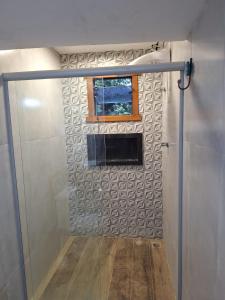 a bathroom with a glass shower door with a window at Rancho Primavera in Santana do Riacho +72 photos