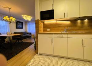 a kitchen with a sink and a living room with a table at Ferienwohnung Waldrose am Titisee in Titisee