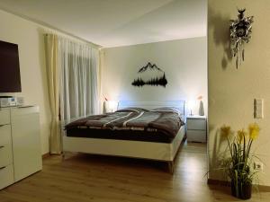 a bedroom with a bed with a mountain on the wall at Ferienwohnung Waldrose am Titisee in Titisee