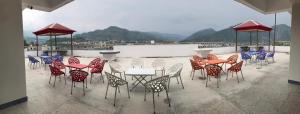 a group of tables and chairs with mountains in the background at River View Hotel in Heart of Muzaffarabad,213 in Muzaffarabad