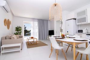 a white kitchen and living room with a table and chairs at serene villas in Ierapetra