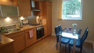 a kitchen with a table and chairs and a sink at eApartments in Edinburgh