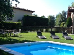 a yard with chairs and a table and a pool at La Cabanya del Permanyer in Sant Genís