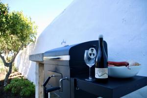 a grill with a bottle of wine and a glass at MATER RANDA, piscina, vistas increíbles y barbacoa in Randa