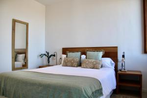 a bedroom with a large white bed with pillows at MATER RANDA, piscina, vistas increíbles y barbacoa in Randa