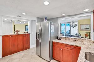 a kitchen with a stainless steel refrigerator at Oceanfront condo with direct beach access, pool, balcony, grilling area, & AC in Fernandina Beach +30 photos
