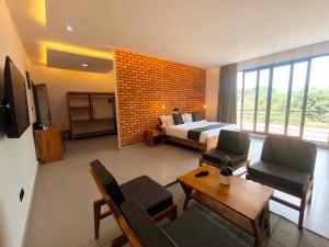 a hotel room with a bed and a living room at Résidence Ermitage in Ouidah