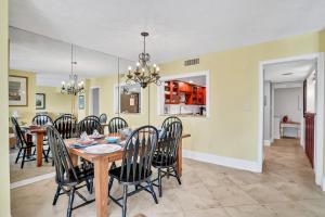 a dining room and living room with a table and chairs at Oceanfront condo with direct beach access, pool, balcony, grilling area, & AC in Fernandina Beach