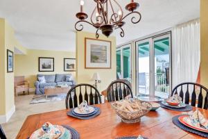 a dining room with a wooden table with chairs at Oceanfront condo with direct beach access, pool, balcony, grilling area, & AC in Fernandina Beach
