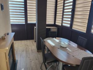 a dining room with a table and some windows at Apartament Alice & Denis in Tohanu Nou +3 photos