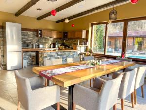 a kitchen and dining room with a wooden table and chairs at Къща за гости Гергана in Ribarica