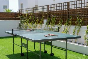 a ping pong table sitting on top of grass at Fig Tree Beach Villa One in Protaras