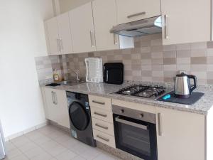a kitchen with a stove top oven next to a microwave at Les belles loges in Bouskoura